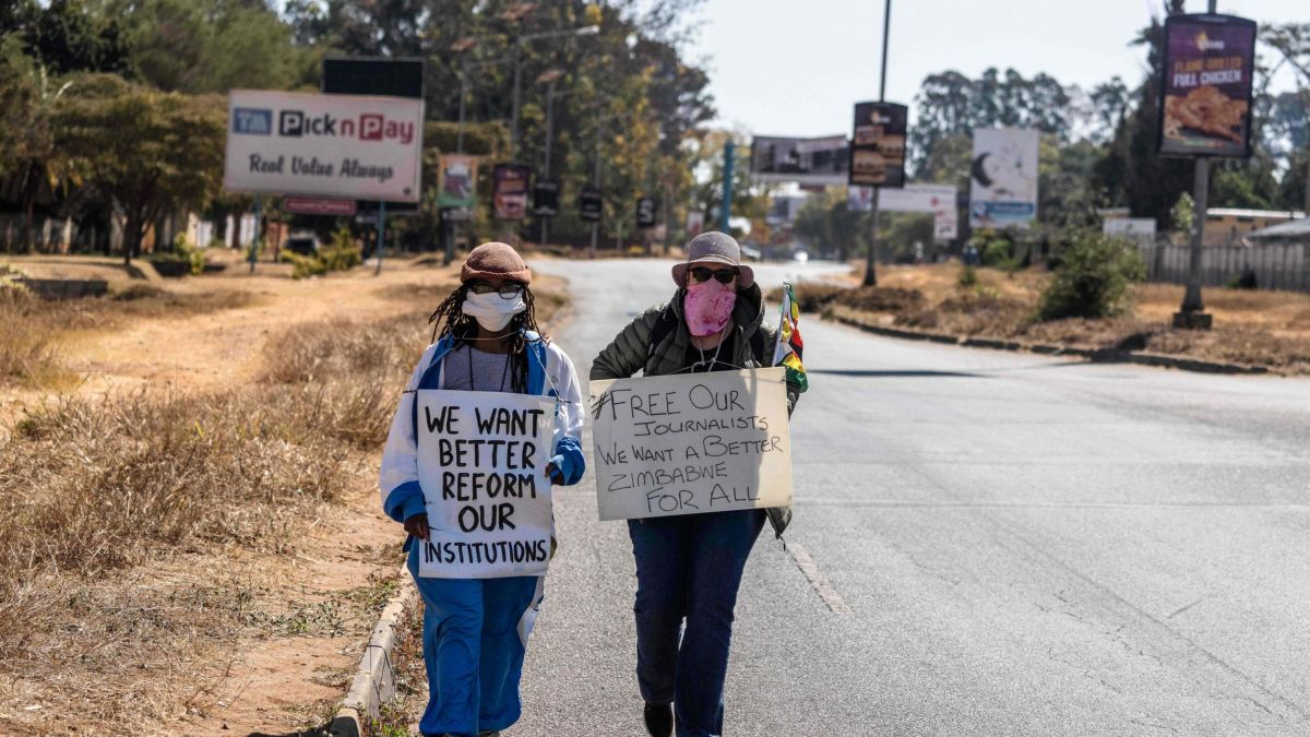 Zimbabwean novelist Tsitsi Dangarembga (L) and a colleague Julie Barnes hold placards during an anti-corruption protest march on July 31, 2020 in Harare.